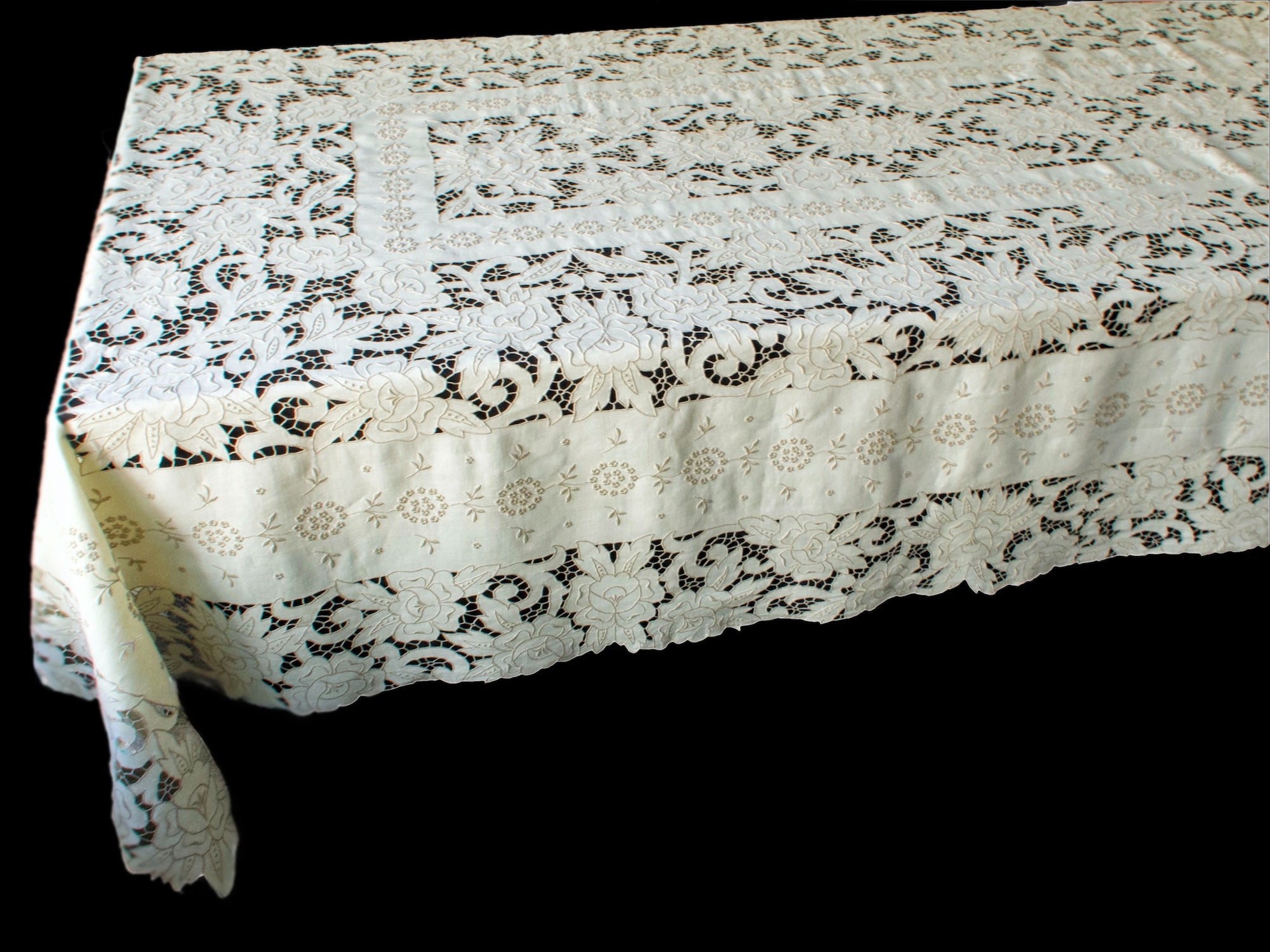 Hand-embroidered corner detail of Madeira Richelieu tablecloth, with openwork bridges and fine satin stitching.