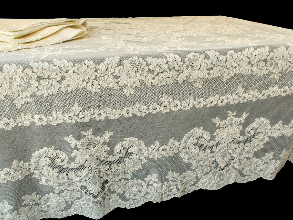 Set of Alençon lace napkins sitting on top of a vintage lace tablecloth