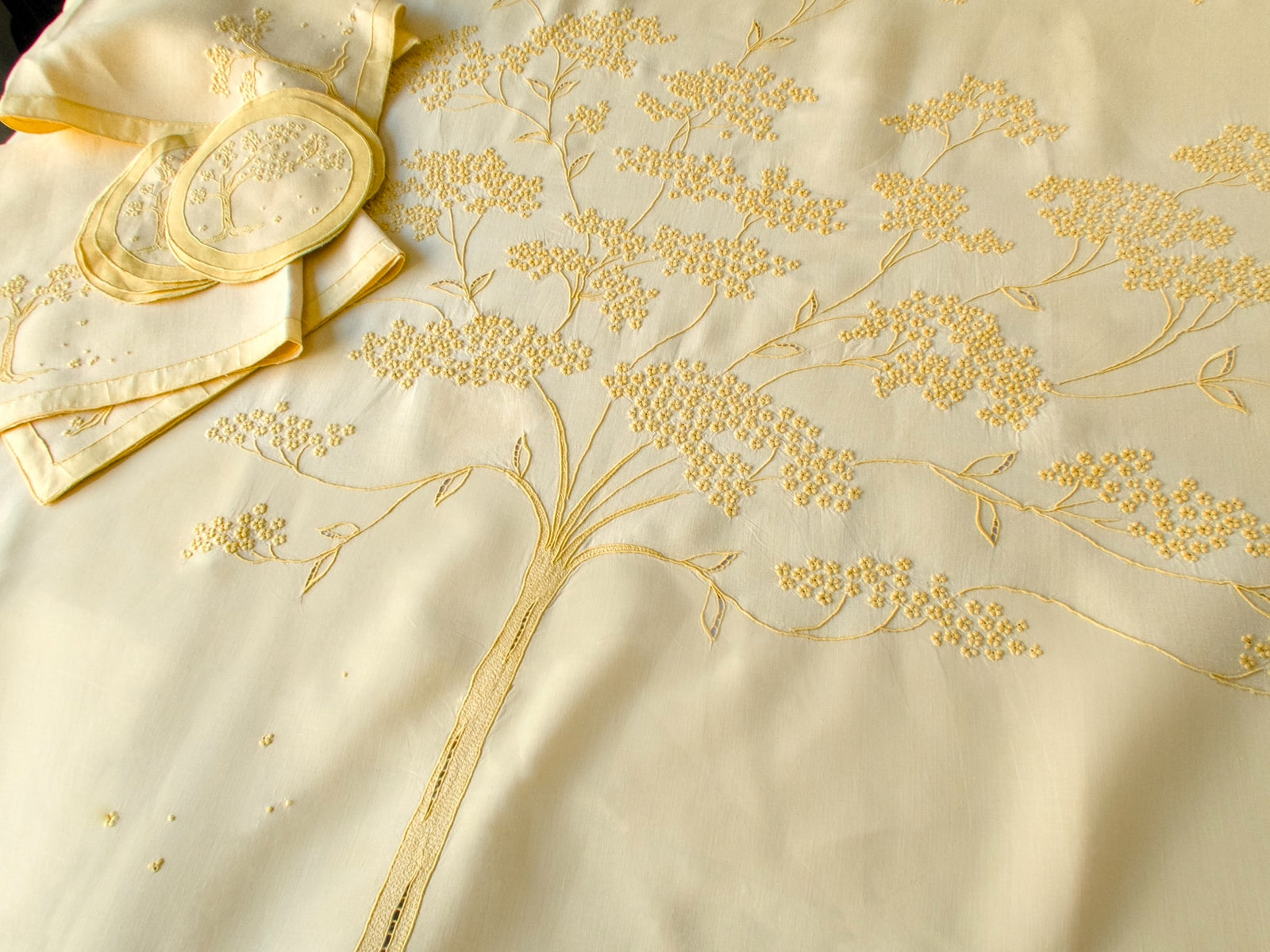 Detail of Madeira embroidery stitches on yellow Marghab Jacaranda Tree tablecloth