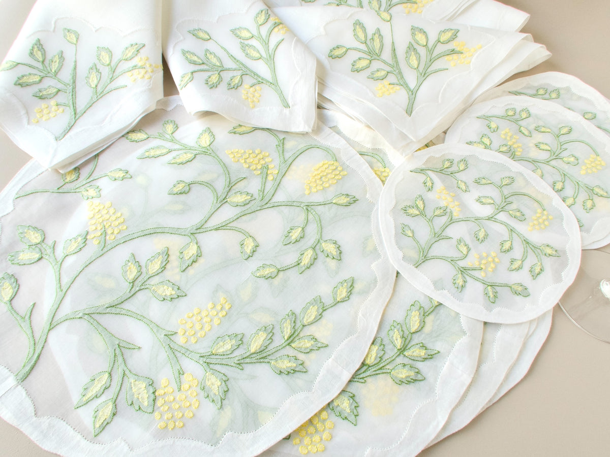Full 18-piece vintage Madeira Jacobean shadow work placemat set showing six placemats, six napkins and six coasters laid out on beige background