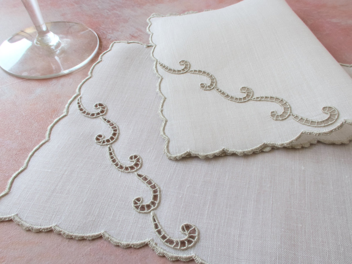 Embroidered Marghab vintage cocktail napkins in the Simplicity pattern with a glass in the background