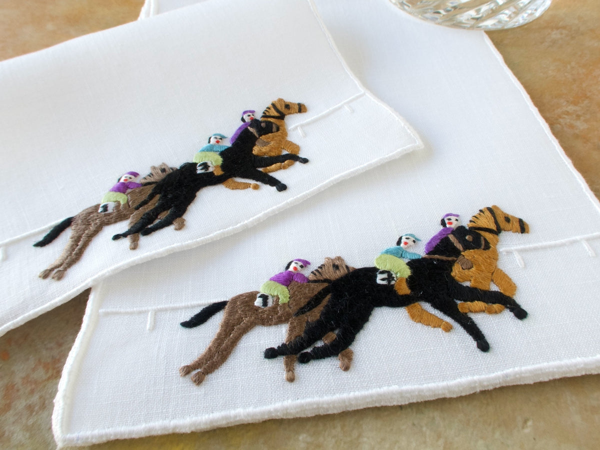 Vintage Madeira cocktail napkins hand embroidered with jockeys racing horses, two napkins overlapped