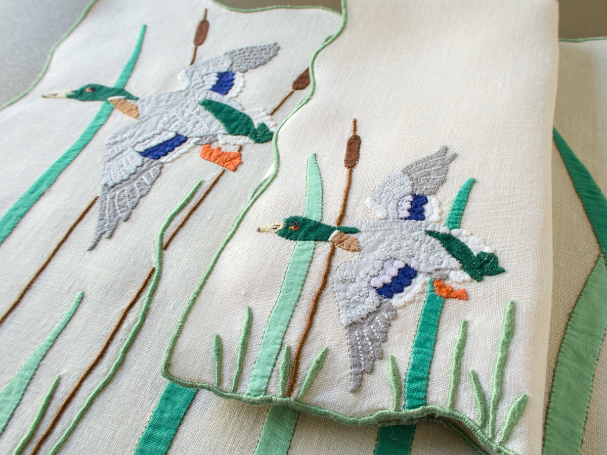 Vintage Madeira mallard placemat and folded napkin, each with a flying drake, cattails and green appliqué reeds