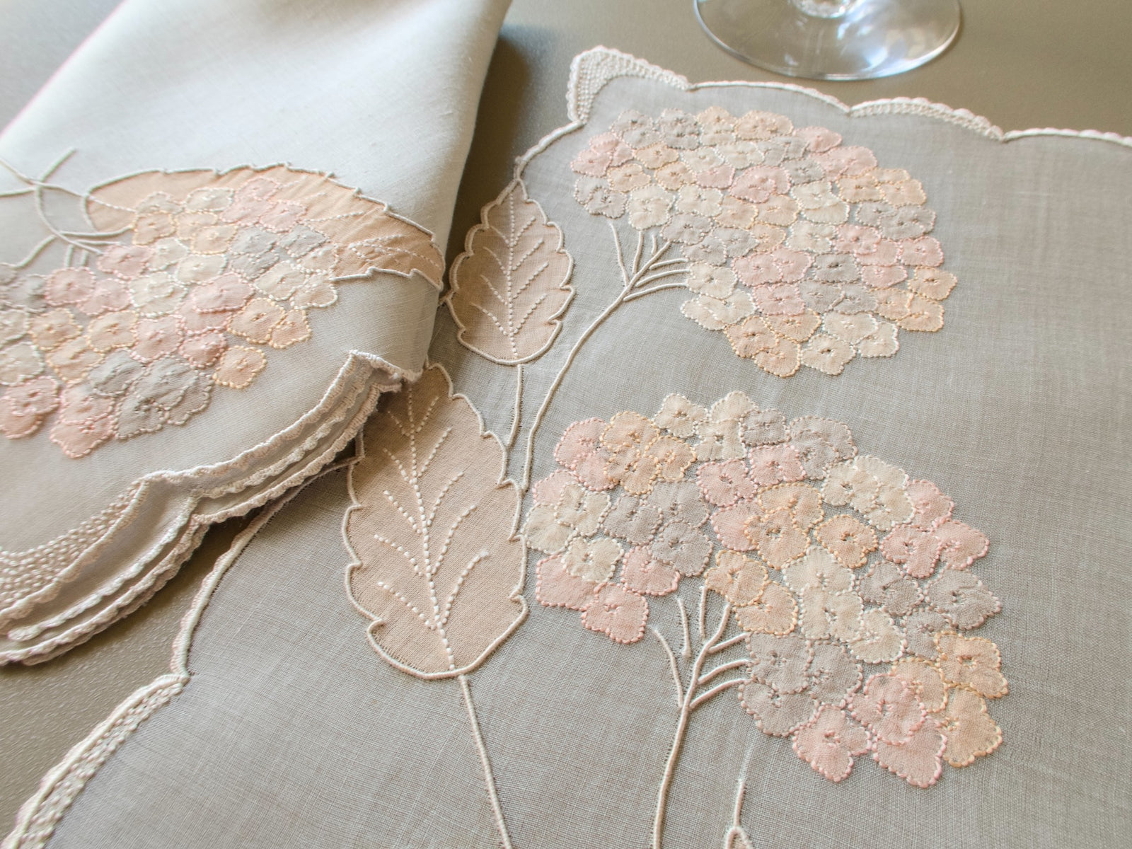 Vintage Marghab “Hydrangea” placemat and napkin set, hand embroidered in Madeira on fine organdy and linen, featuring intricate hydrangea blossoms in soft shades of cream and beige.