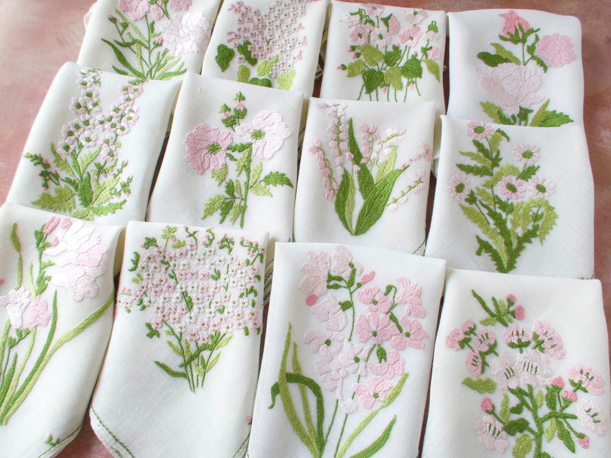 Matching pink Rapisardi napkins with individual floral embroidery and trembler butterfly detail.