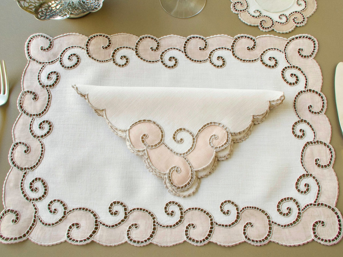 Full vintage Marghab "Open Scroll" placemat with Richelieu scroll border, a folded napkin, a coaster and a wine glass