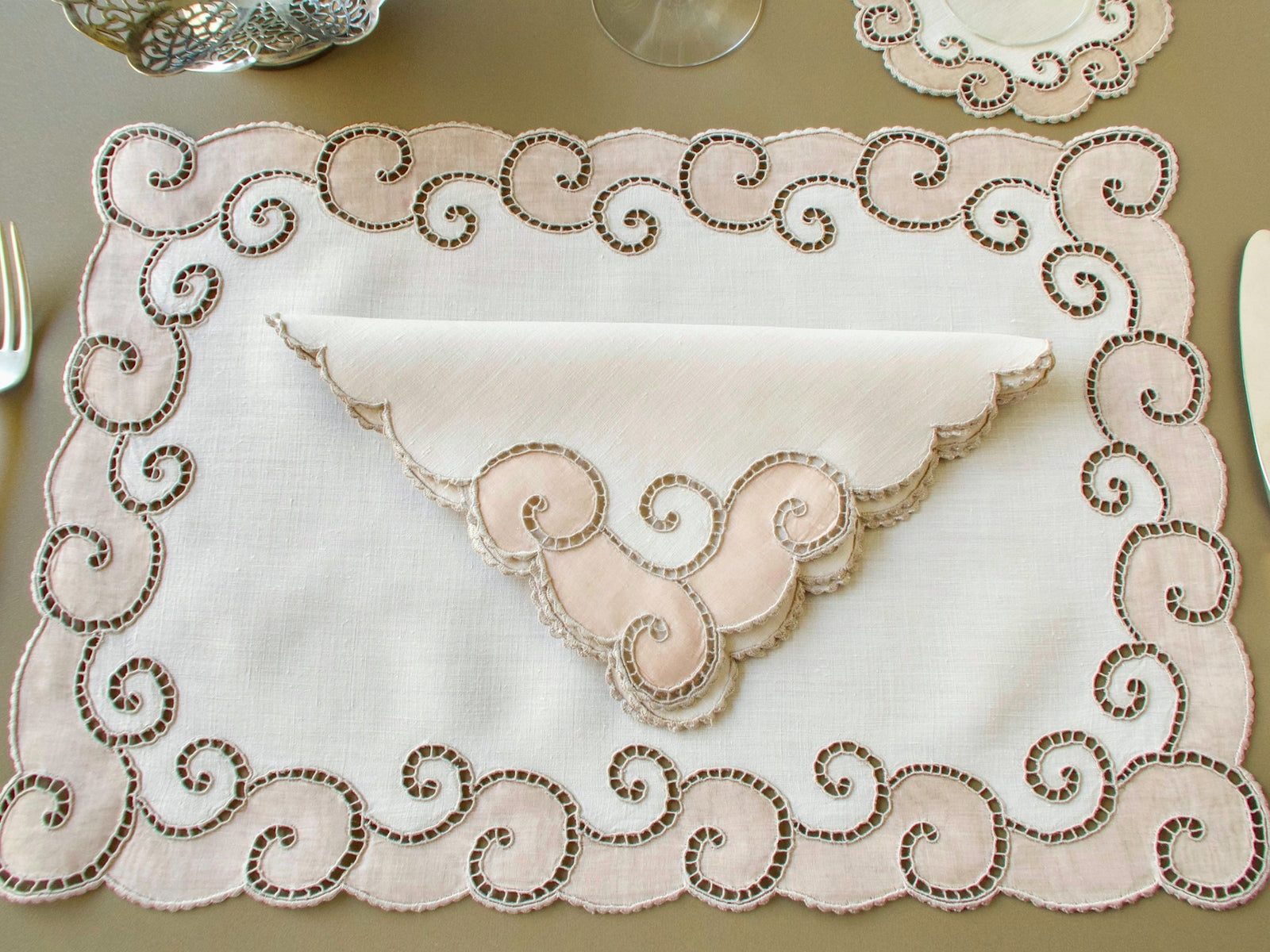 Full vintage Marghab "Open Scroll" placemat with Richelieu scroll border, a folded napkin, a coaster and a wine glass