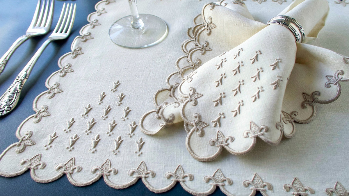 Vintage Marghab Old France placemat and napkin set in ivory linen, hand embroidered with scalloped fleur-de-lis borders and delicate fleur-de-lis motifs.