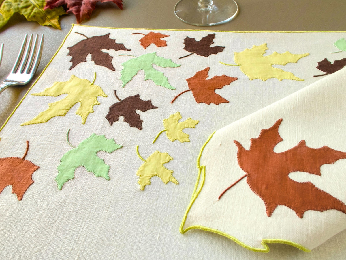 Close view of vintage Marghab "Autumn Leaves" appliqué leaves in brown, rust, pale green and yellow on linen