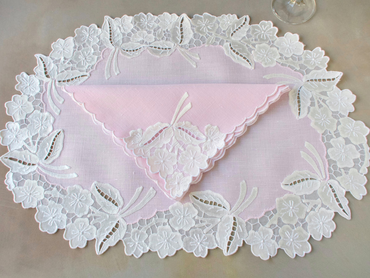 Pink linen placemat with white Madeira embroidery, organdy honeycomb border and matching scalloped napkin.