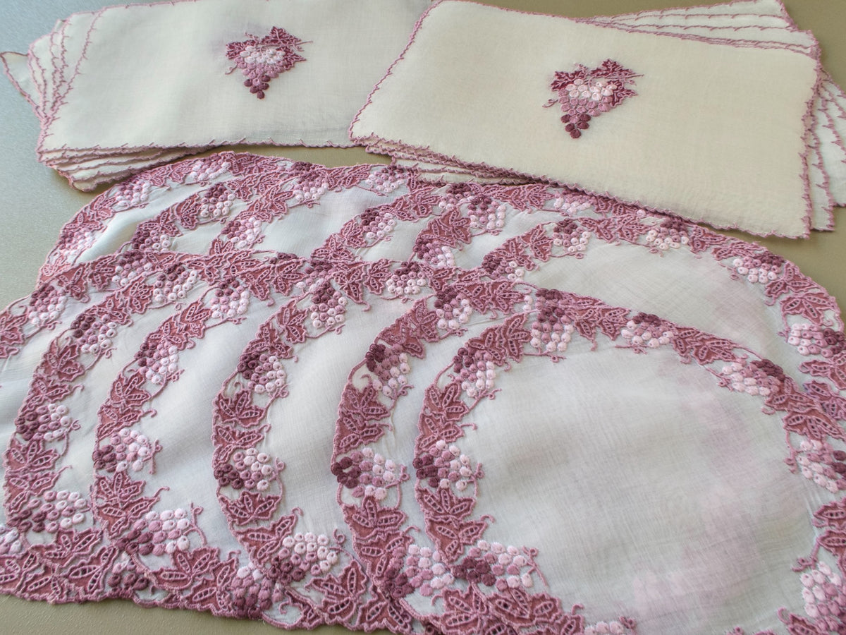 Vintage Marghab Vineyard organdy coasters with grape and leaf borders beside stacked cocktail napkins with a single grape cluster