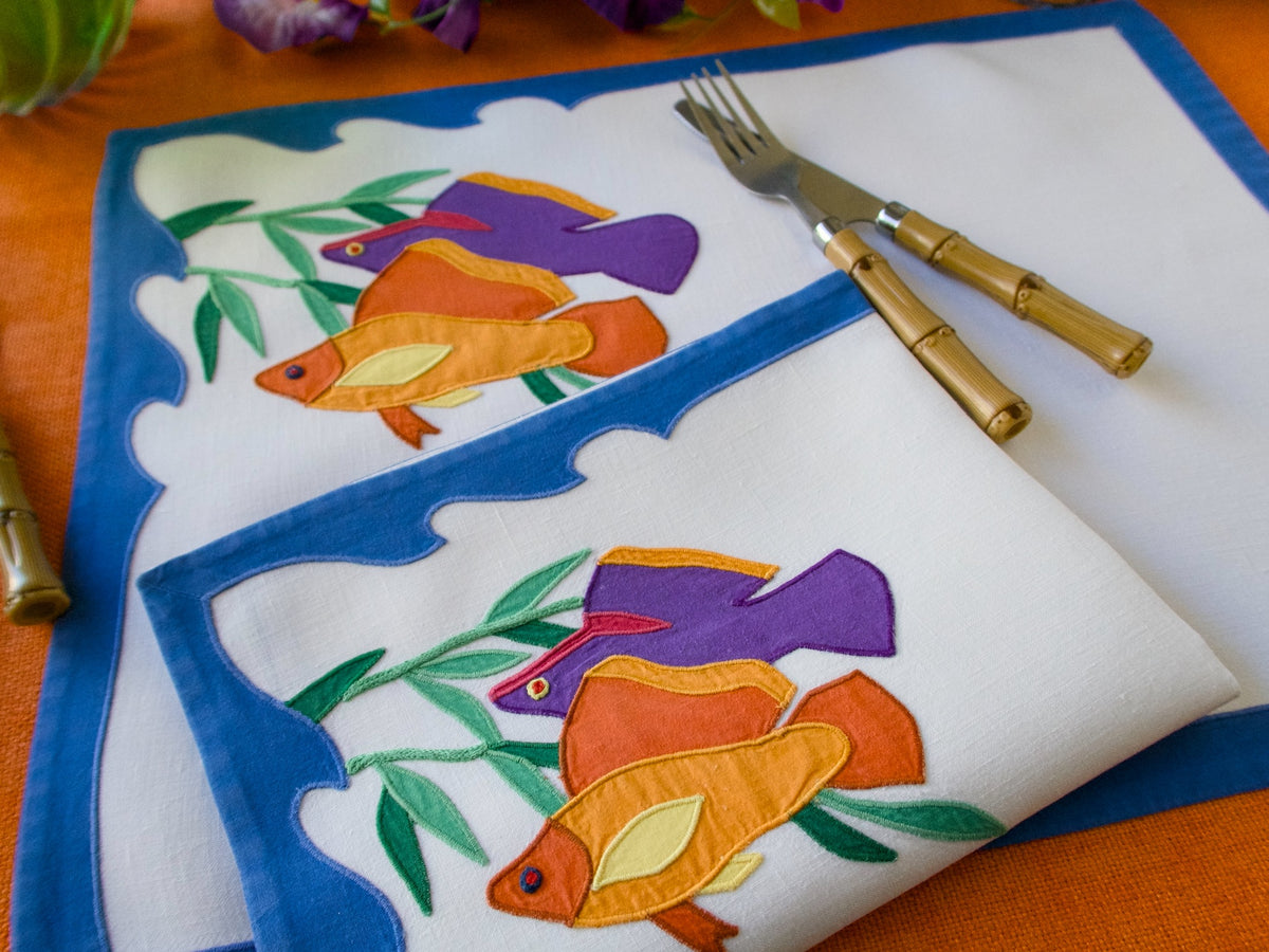 Orange and purple tropical fish embroidered on linen placemats