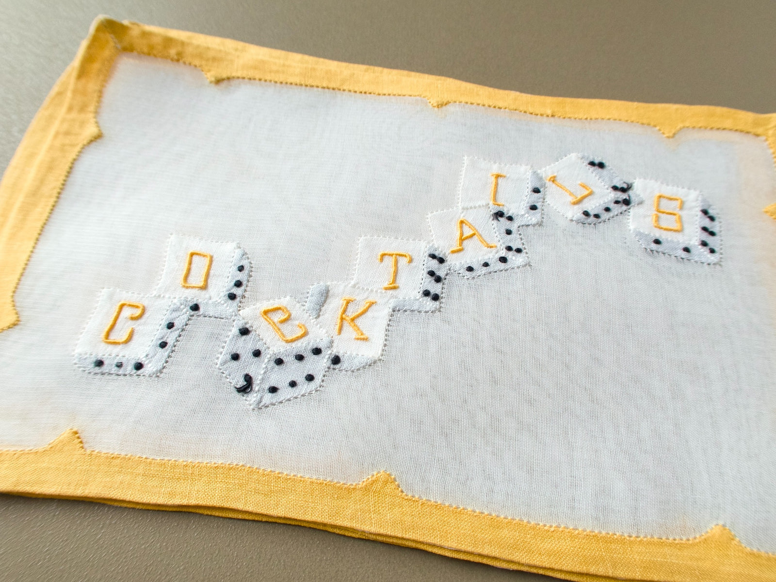 Stacked vintage Madeira cocktail napkins, showing the dice spelling “COCKTAILS”
