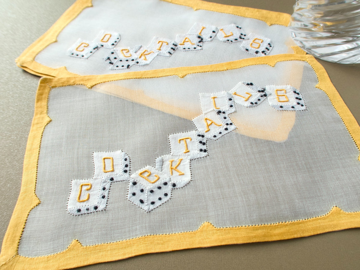 Vintage Madeira organdy cocktail napkins arranged to show the appliqué dice and yellow borders.