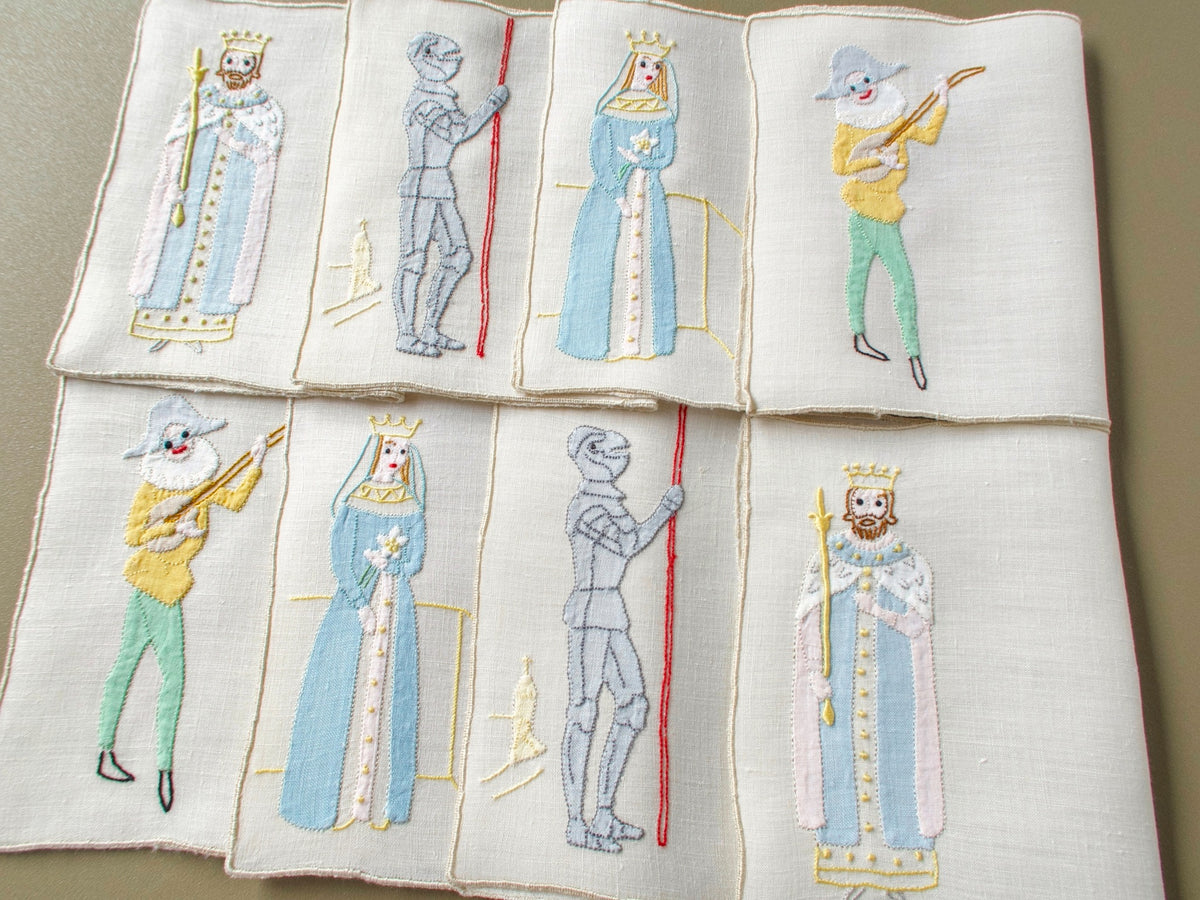 Eight vintage Madeira cocktail napkins laid out in two rows, each pair showing a king, jack, queen or lute-playing joker