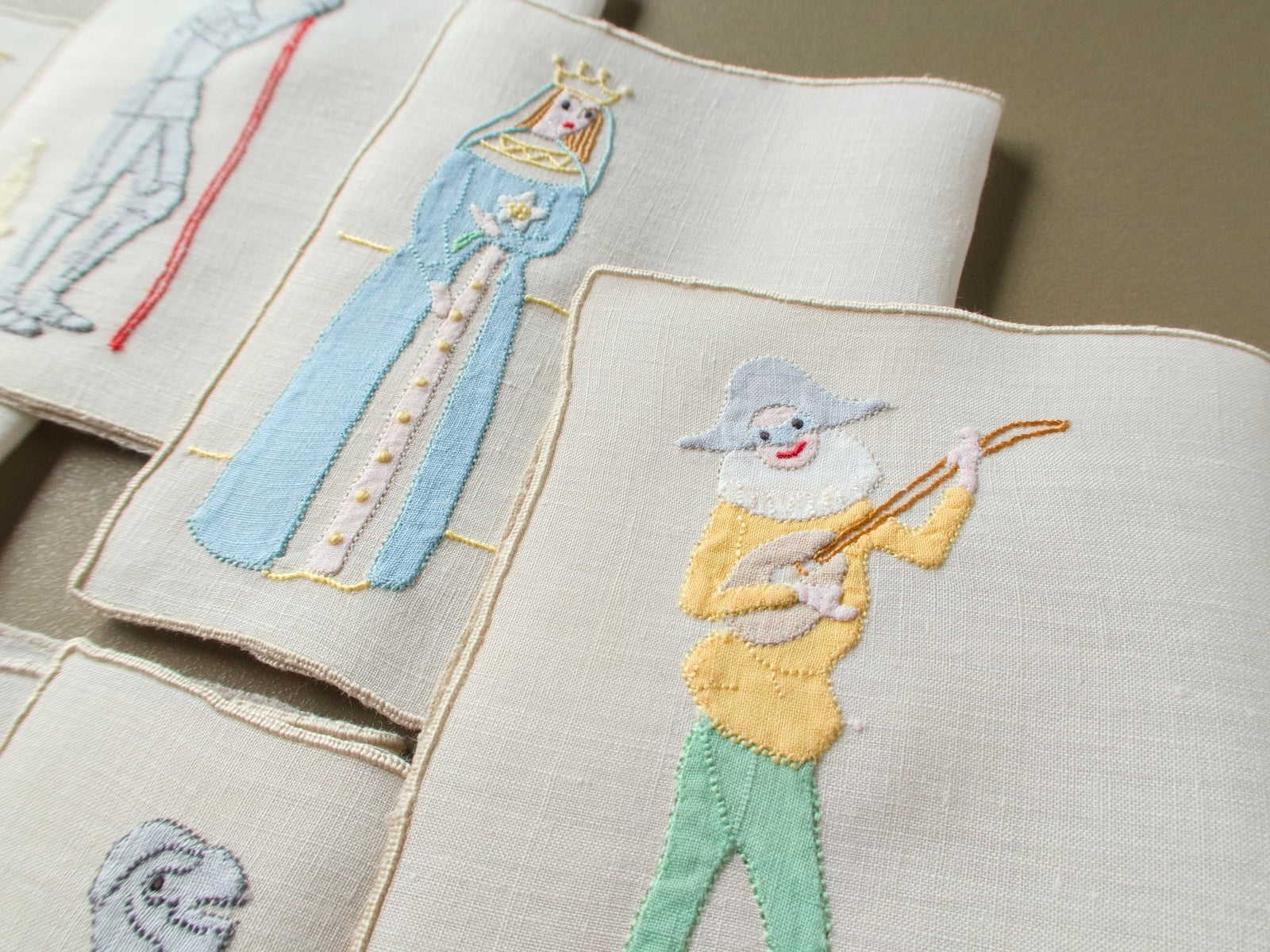 Vintage Madeira cocktail napkins with an appliqué queen and a joker with a lute, edged in cream