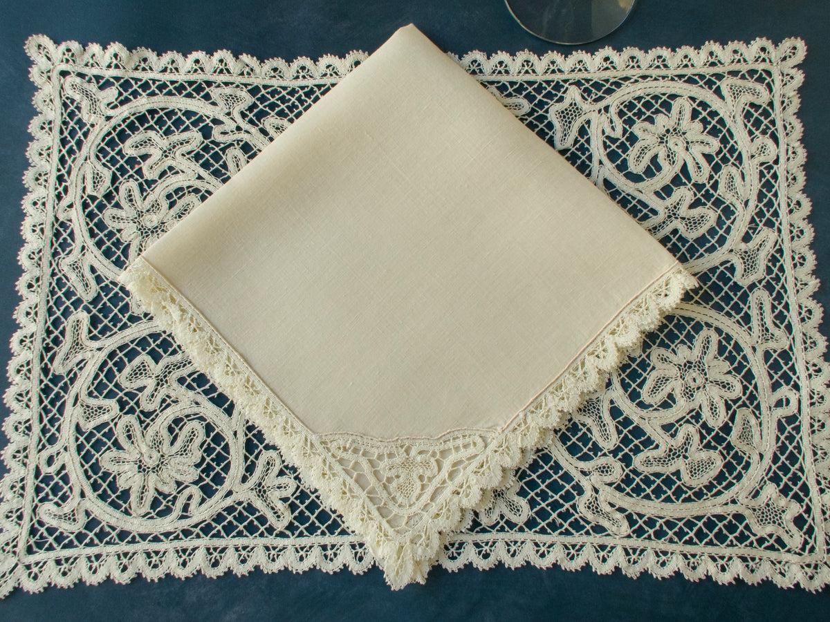 Vintage bobbin lace placemat with square linen napkin, displaying fine handmade lace border and floral motifs.