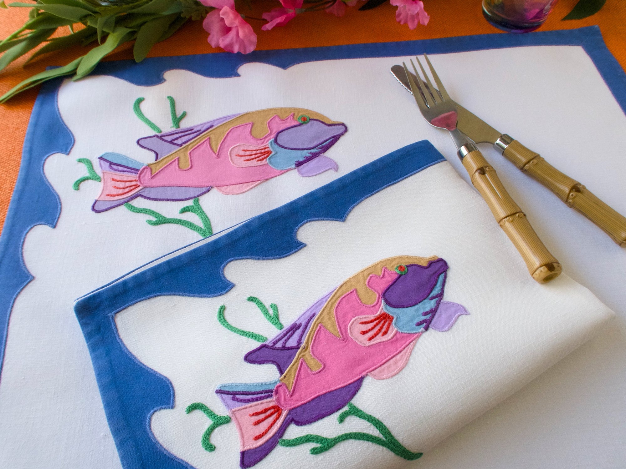 Pink fish embroidered on linen placemats