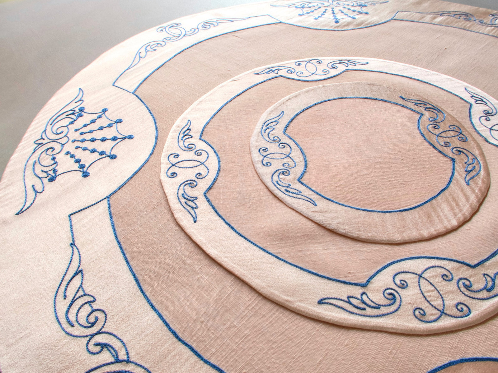 Vintage French Cornely tea dessert set showing centerpiece, placemat and coasters with blue scrollwork on salmon silk and linen