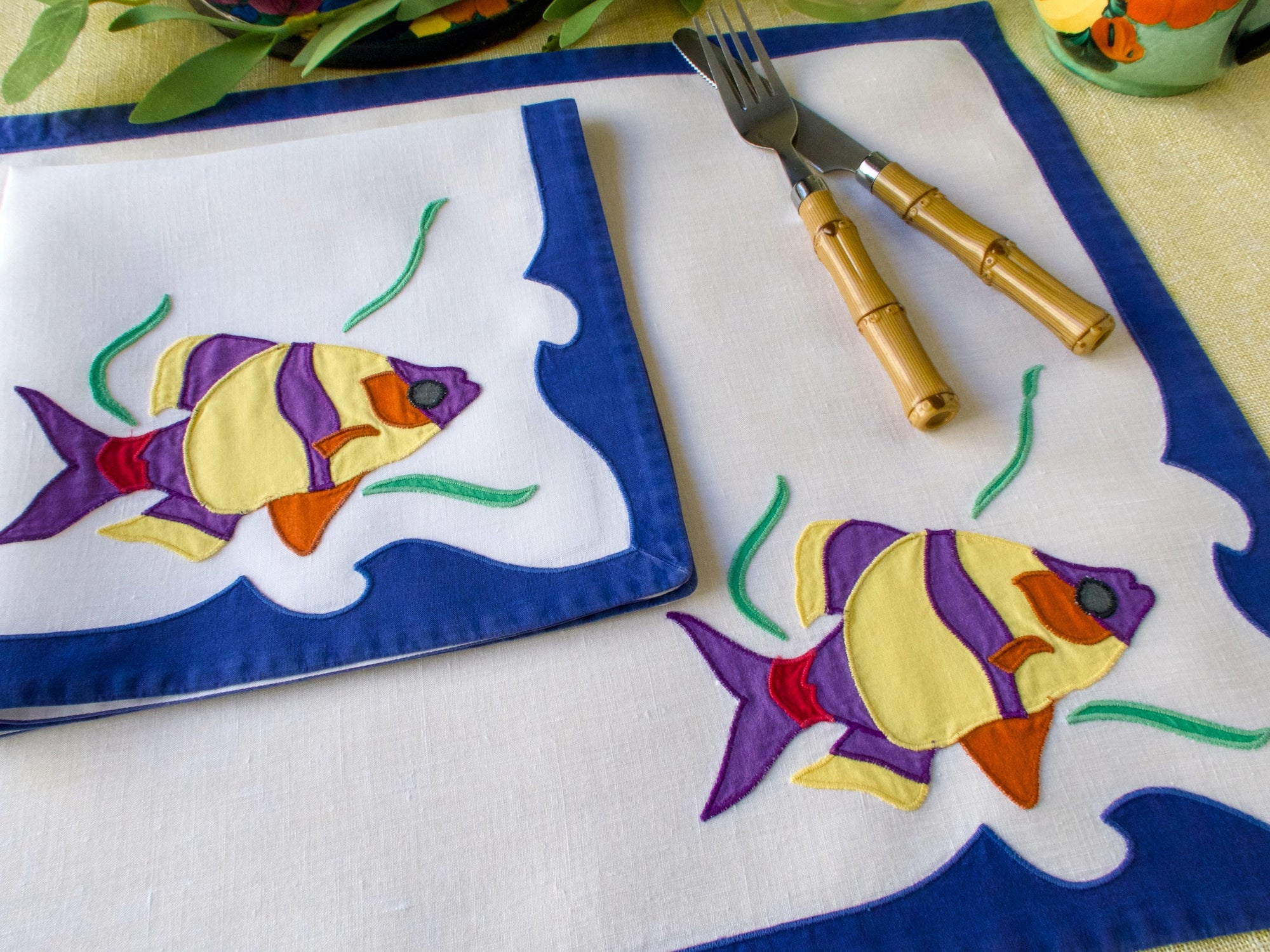 Brightly colored fish embroidered on a placemat set