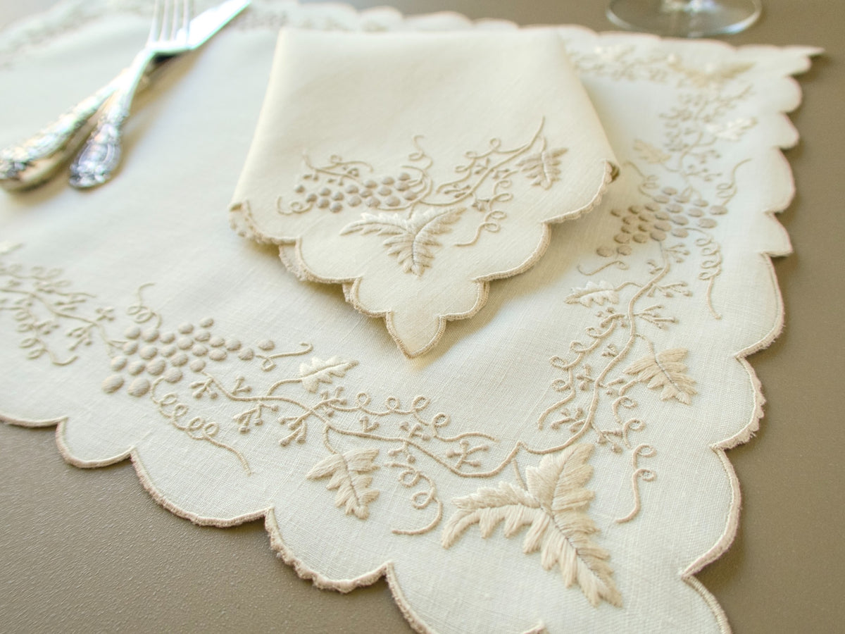 Detail of hand embroidered grape clusters, curling tendrils and leaves on vintage Madeira placemat