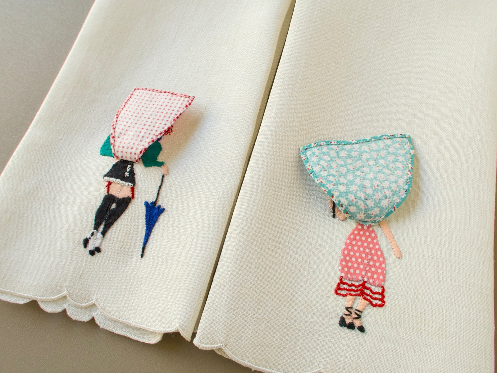 Lifted skirts on the appliquéd ladies of two vintage Madeira linen guest towels, showing the bloomers underneath