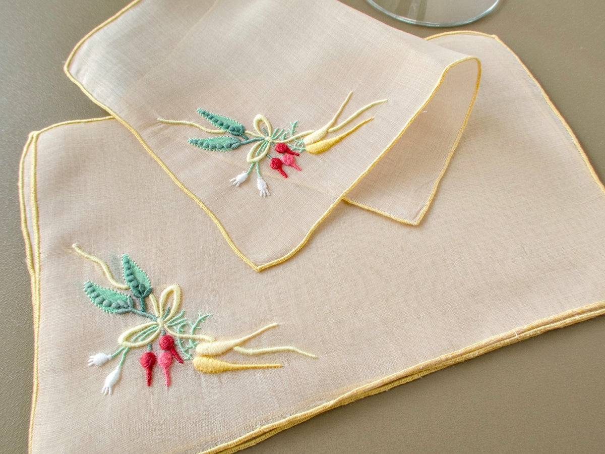 Set of eight vintage Marghab “Carrots & Peas” organdy cocktail napkins showing detailed Madeira embroidery on sheer fabric.