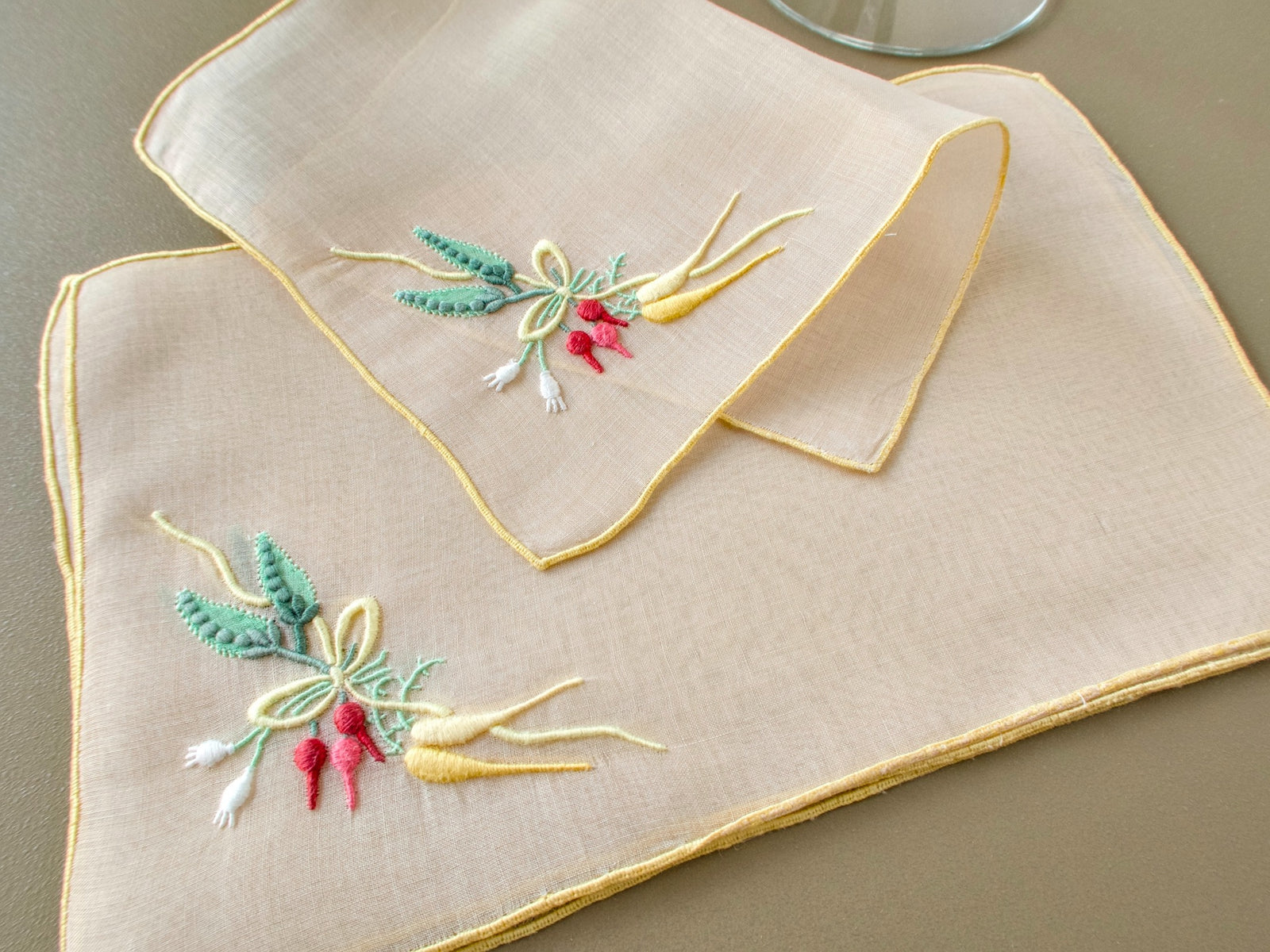 Set of eight vintage Marghab “Carrots & Peas” organdy cocktail napkins showing detailed Madeira embroidery on sheer fabric.