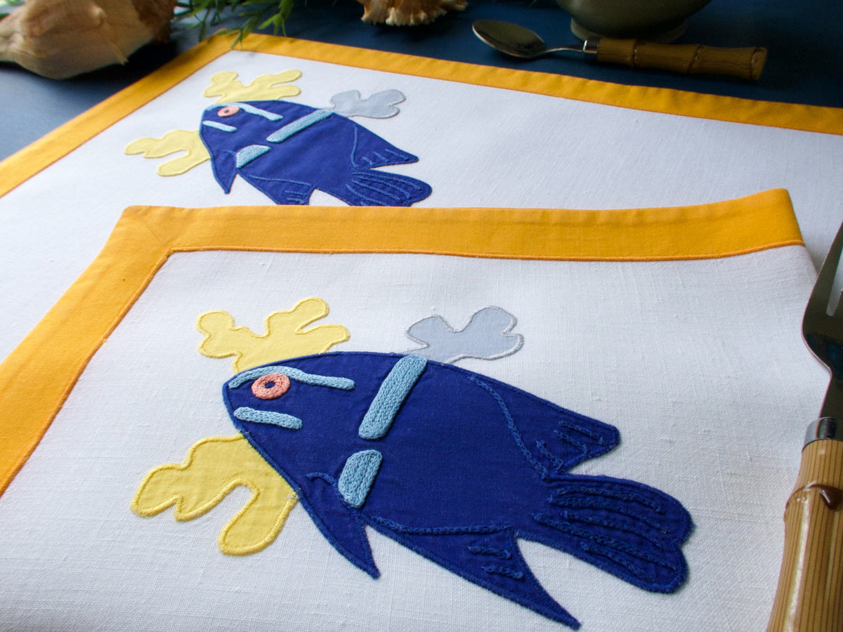 blue fish embroidered on a linen placemat
