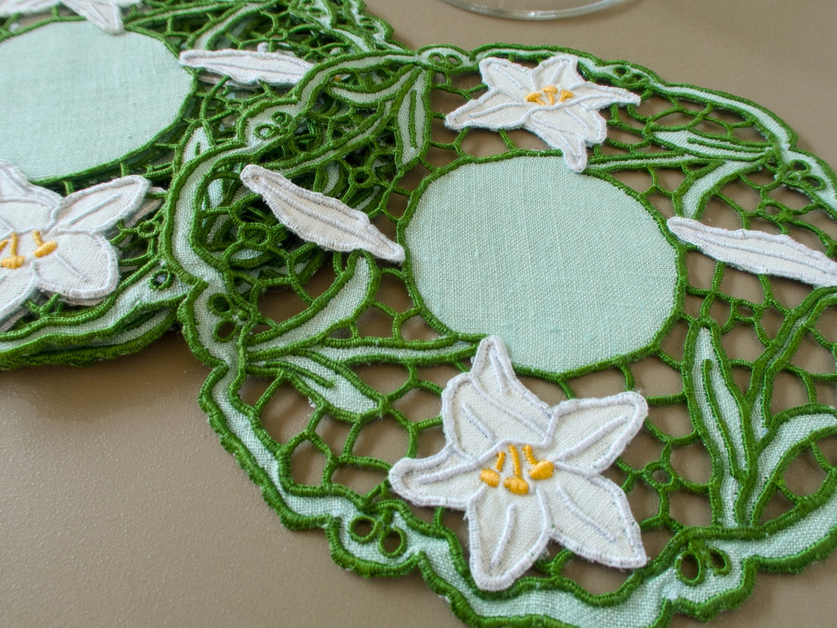 Detail of vintage Madeira cocktail napkins with intricate green Richelieu work, pale green linen and hand embroidered white lilies.