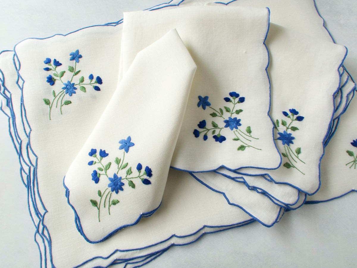Stacked vintage Madeira forget-me-not napkins showing blue scalloped border and embroidery detail​​​​​​​​​​​​​​​​