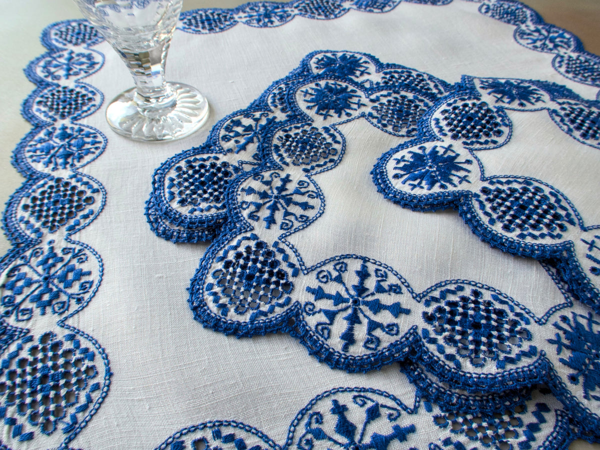 Italian cobalt blue embroidered linen dessert mats and centerpiece set on table with crystal stemware