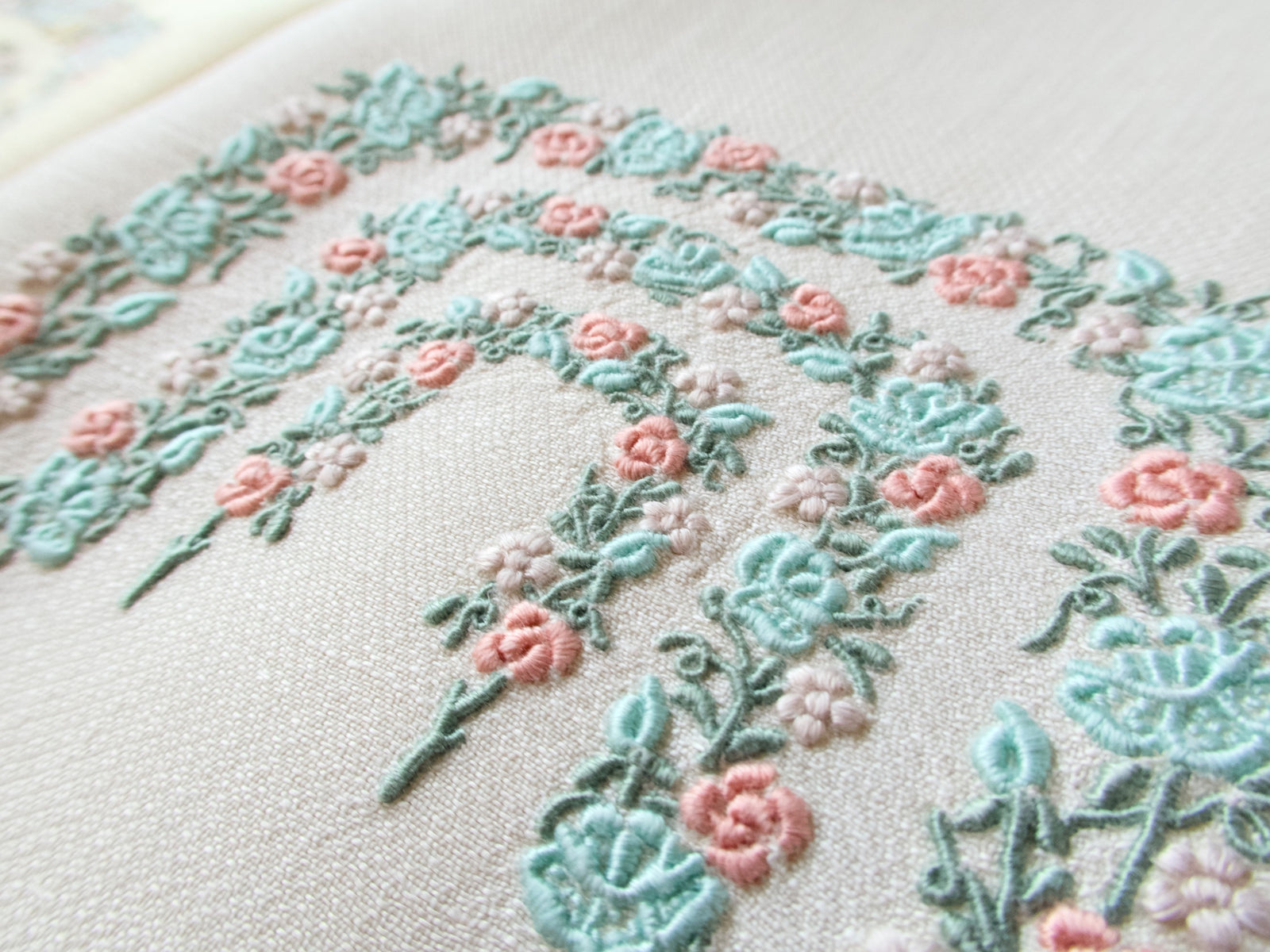Close-up of vintage Marghab Rose Arbor pattern showing pink roses and teal green embroidery on huckaback weave linen.