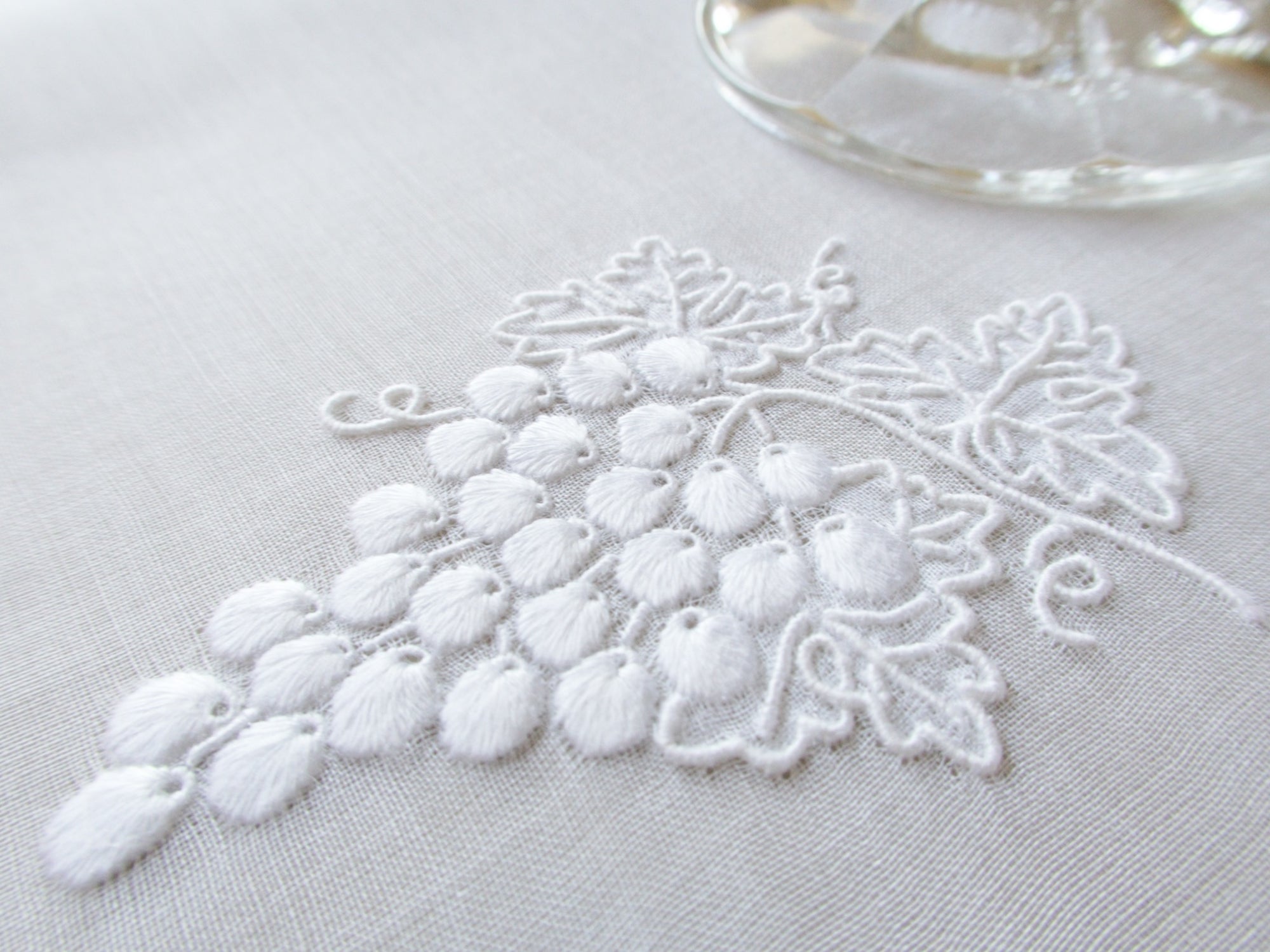 White Marghab Grape & Leaf cocktail napkin, hand embroidered on sheer organdy with raised grape cluster design.