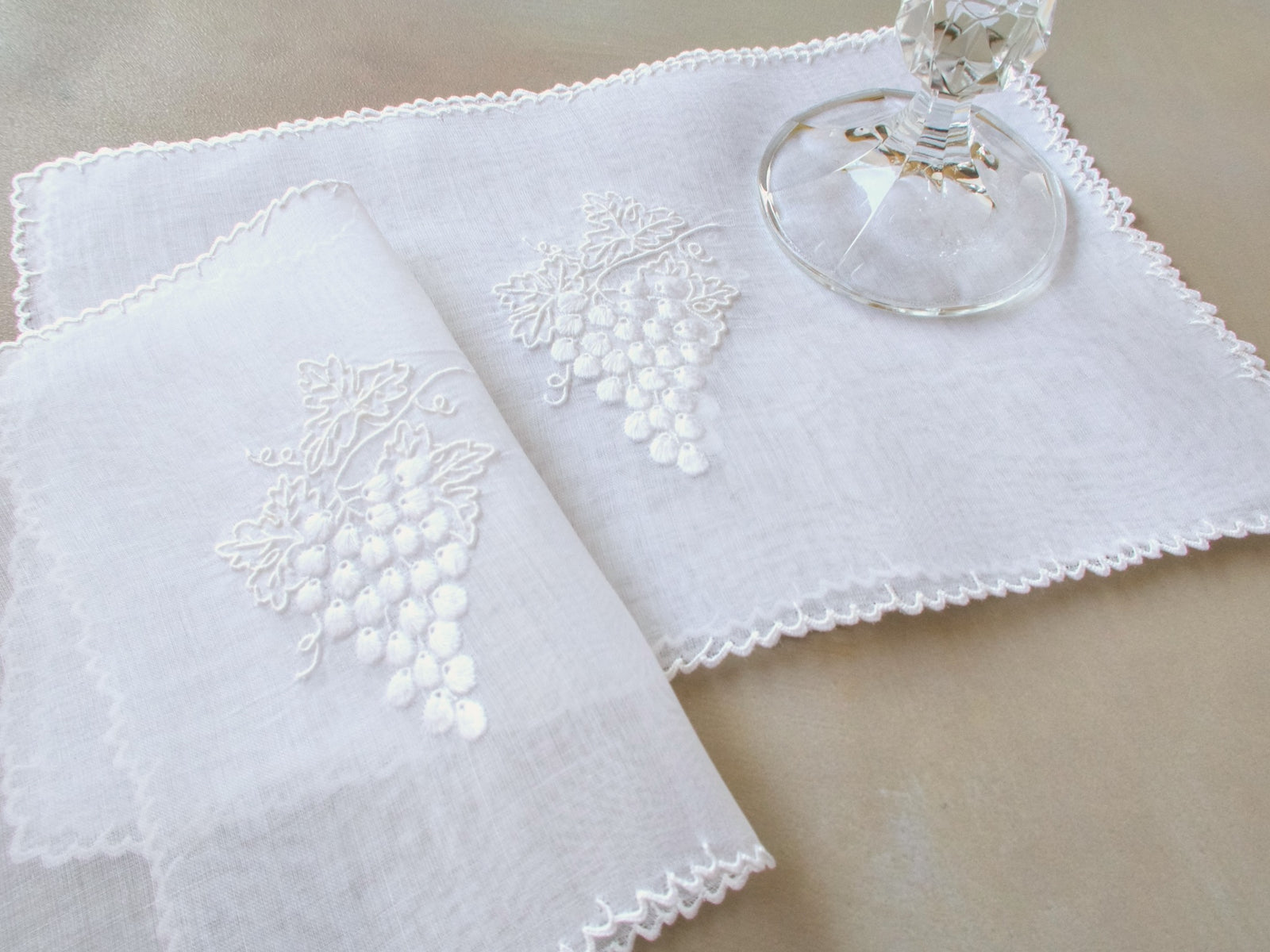 White Marghab Grape & Leaf cocktail napkin, hand embroidered on sheer organdy with raised grape cluster design.