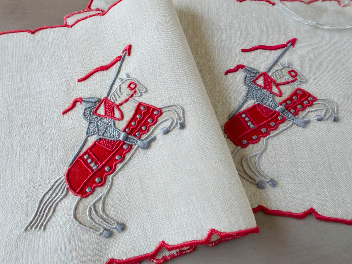 Vintage Marghab Knight pattern cocktail napkins, red embroidery on oyster-colored linen showing knight on horseback, handmade in Madeira.