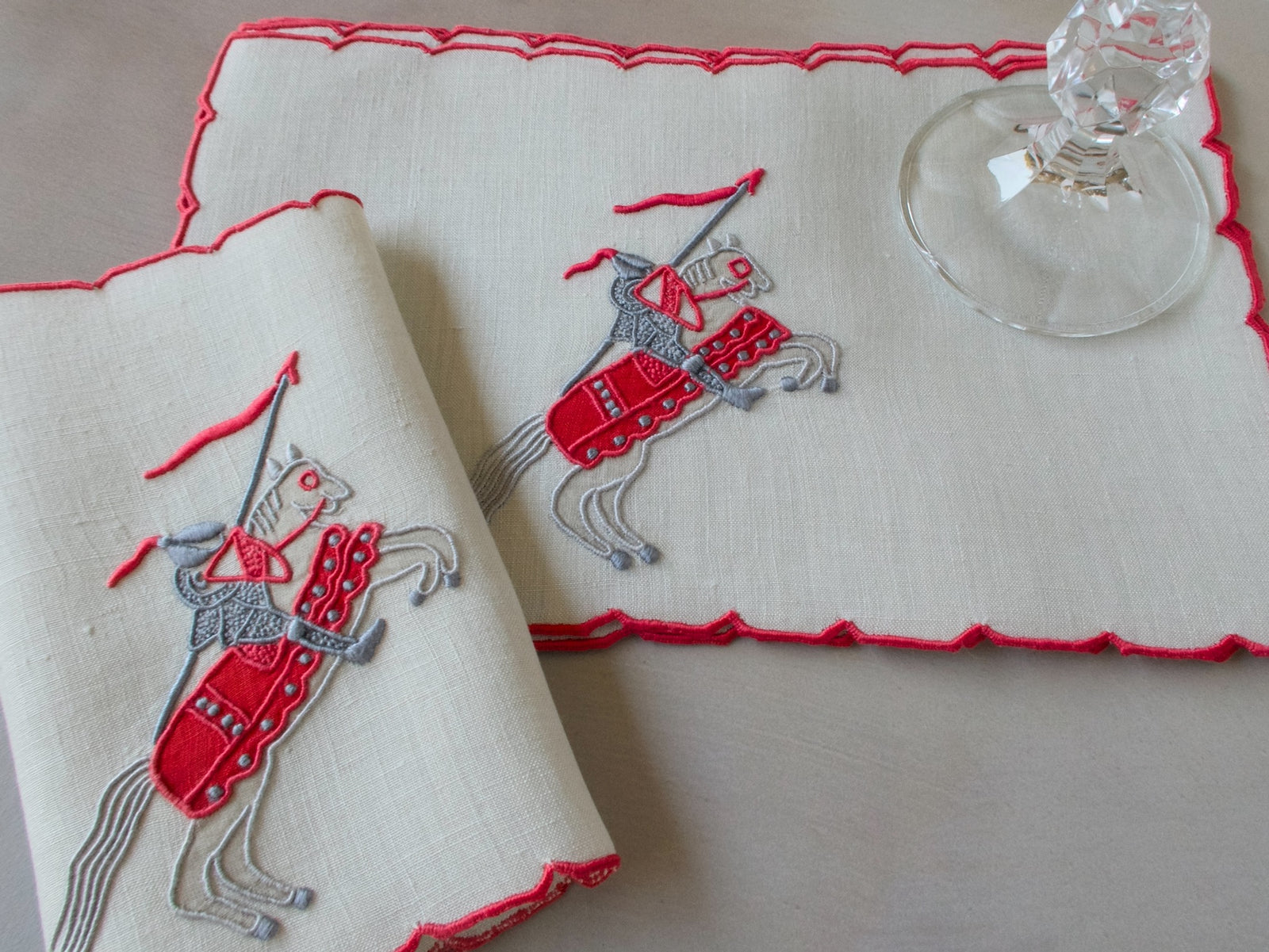 Vintage Marghab Knight pattern cocktail napkins, red embroidery on oyster-colored linen showing knight on horseback, handmade in Madeira.
