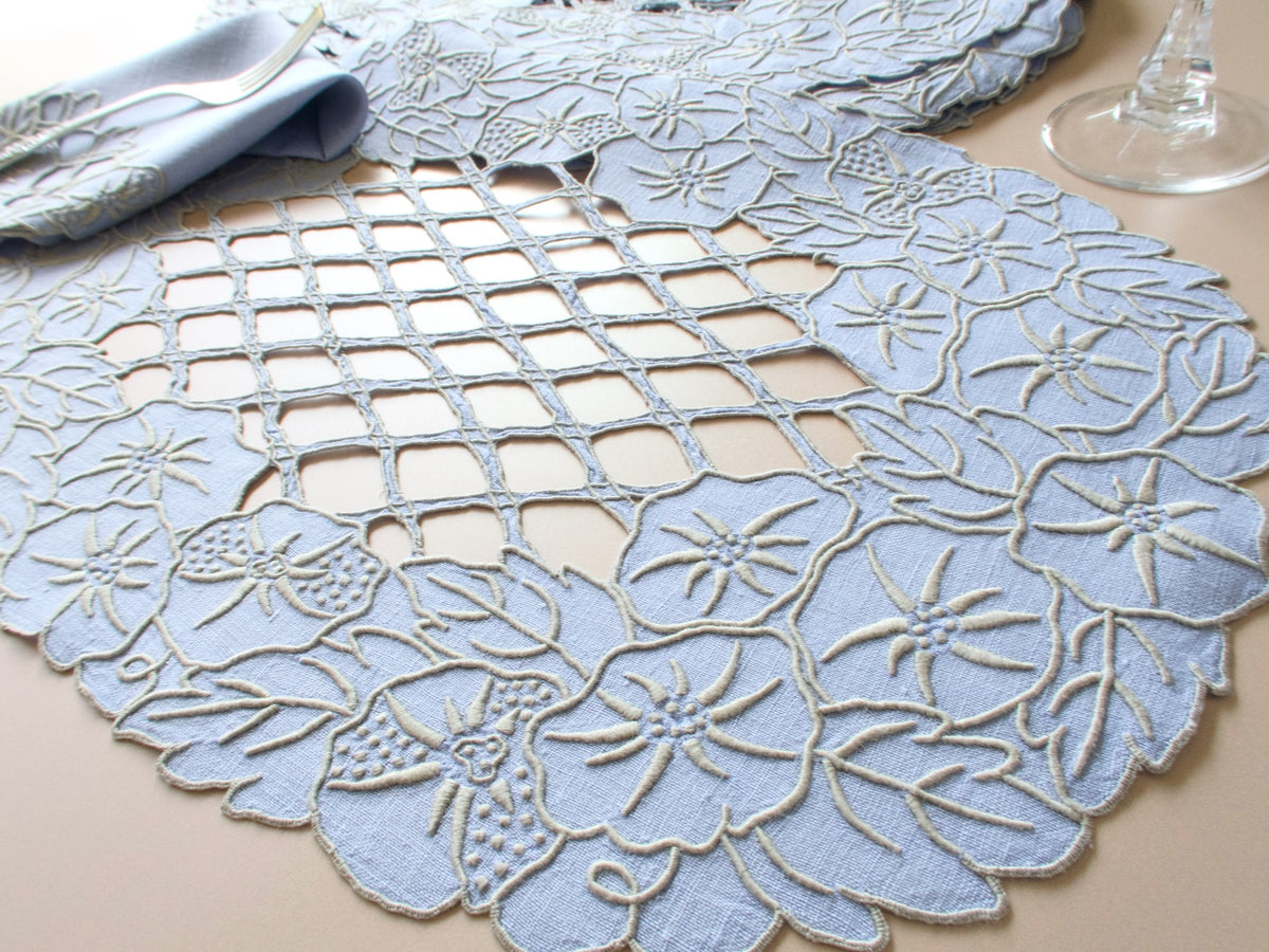 Vintage Madeira linen placemat set, dense morning glory embroidery with open lattice centers, soft chambray blue, setting for 12