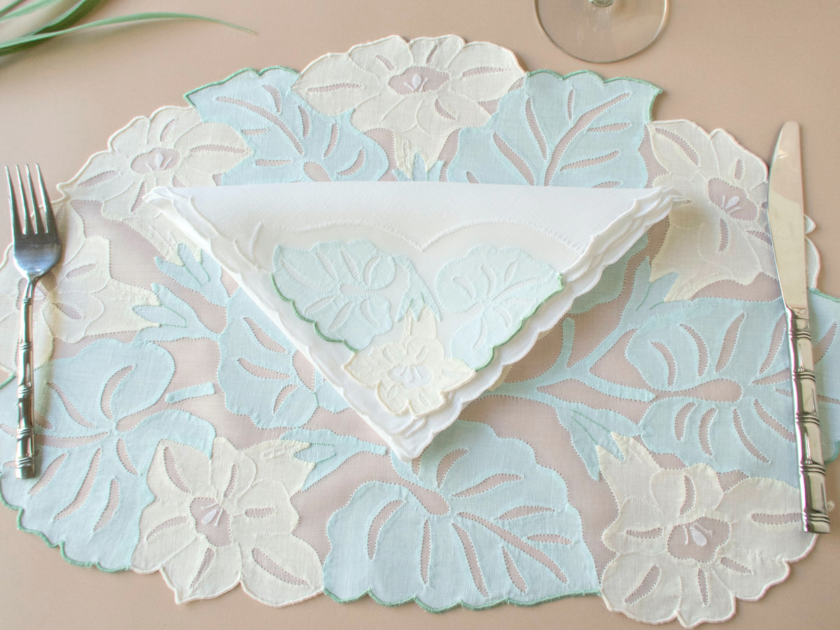 Vintage Madeira organdy placemat set for 12 with fork and napkin showing scale and dimensional embroidered botanical design in soft pastels.