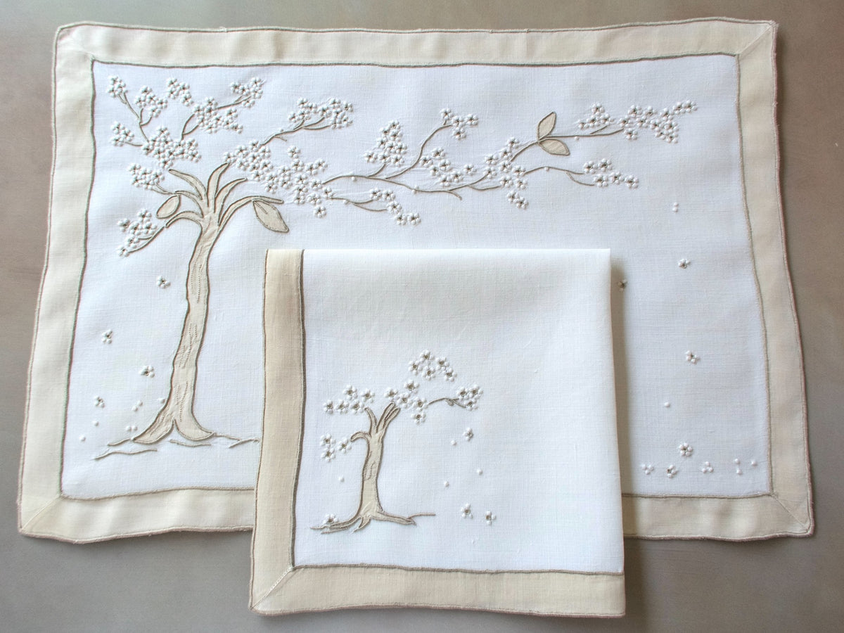 Vintage Marghab “Jacaranda Tree” placemat and napkin set, hand embroidered in Madeira on fine linen with shaded appliqué depicting flowering jacaranda trees inspired by the boulevards of Madeira.