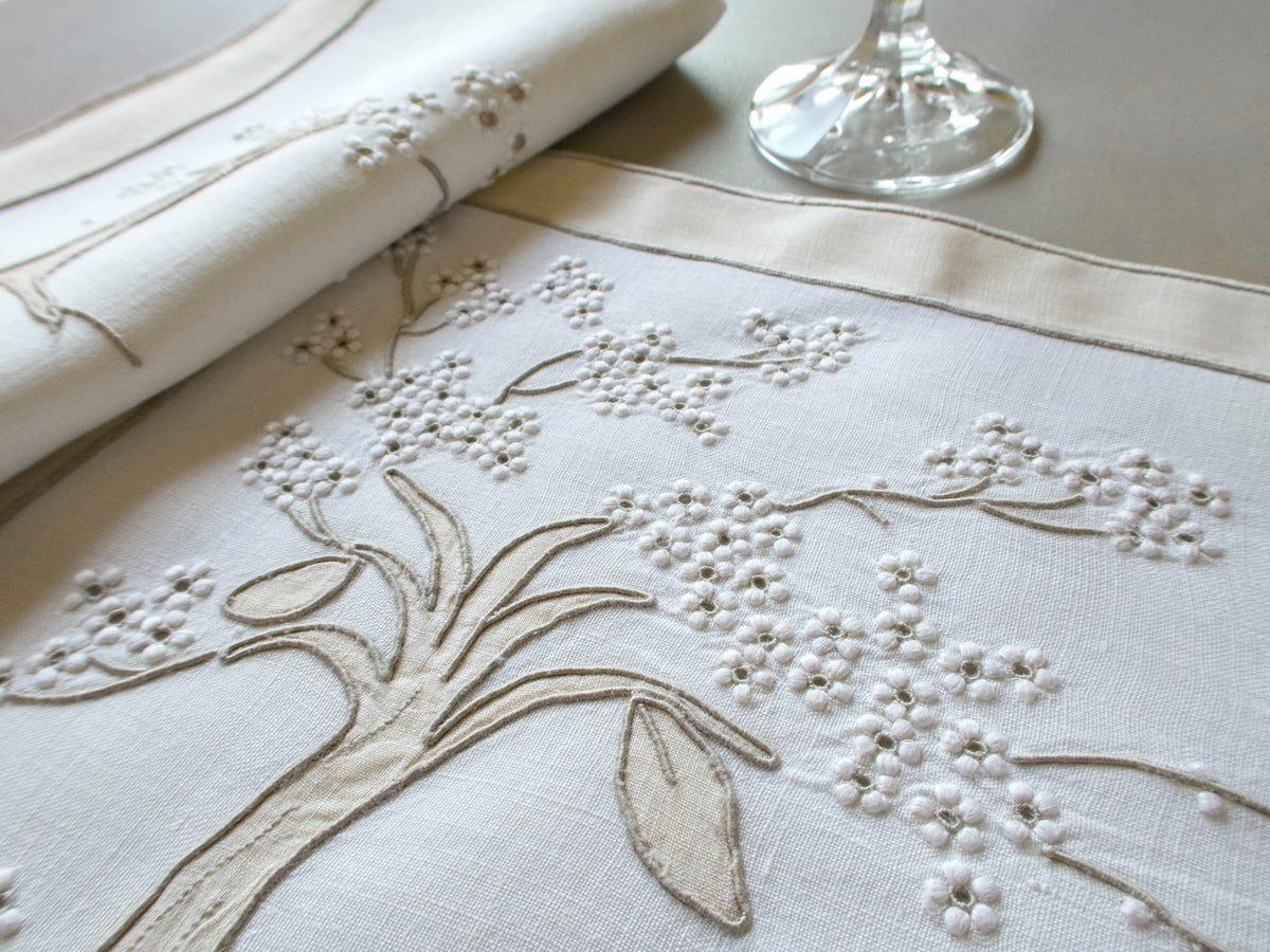 Vintage Marghab “Jacaranda Tree” placemat and napkin set, hand embroidered in Madeira on fine linen with shaded appliqué depicting flowering jacaranda trees inspired by the boulevards of Madeira.