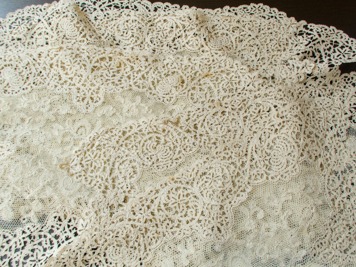 Antique lace placemats overlapping, showing a few remaining storage spots in the bobbin lace