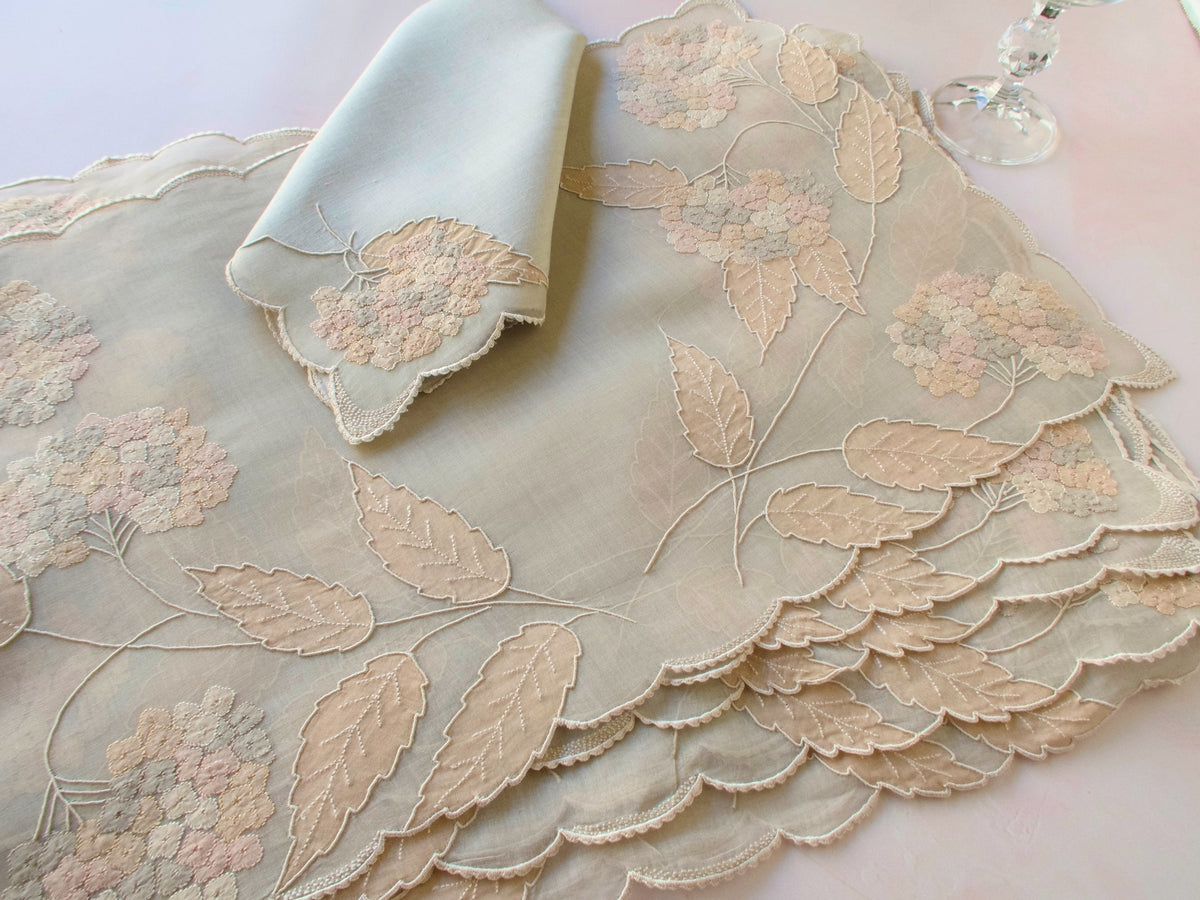 Vintage Marghab “Hydrangea” placemat and napkin set, hand embroidered in Madeira on fine organdy and linen, featuring intricate hydrangea blossoms in soft shades of cream and beige.