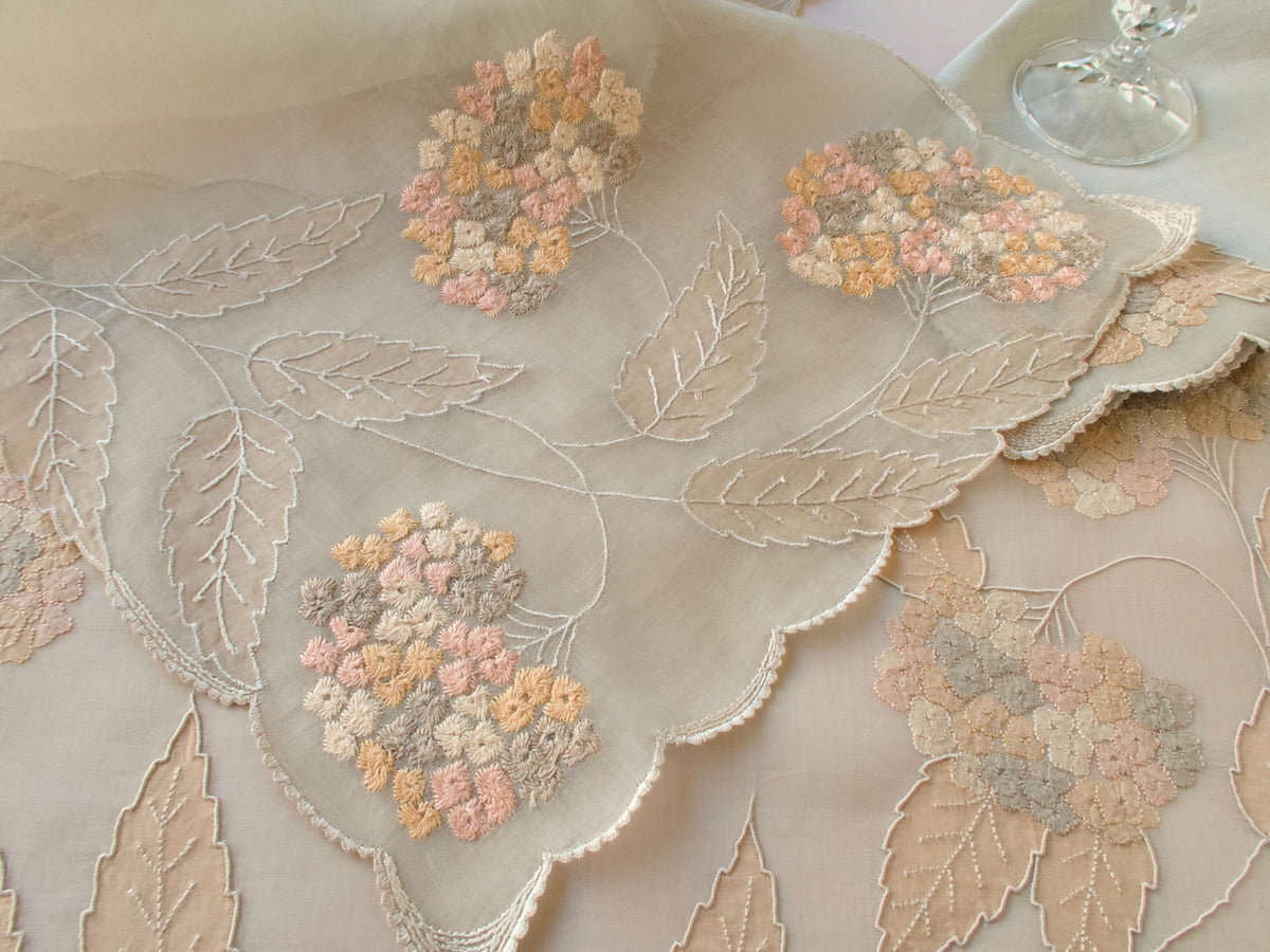 Vintage Marghab “Hydrangea” placemat and napkin set, hand embroidered in Madeira on fine organdy and linen, featuring intricate hydrangea blossoms in soft shades of cream and beige.