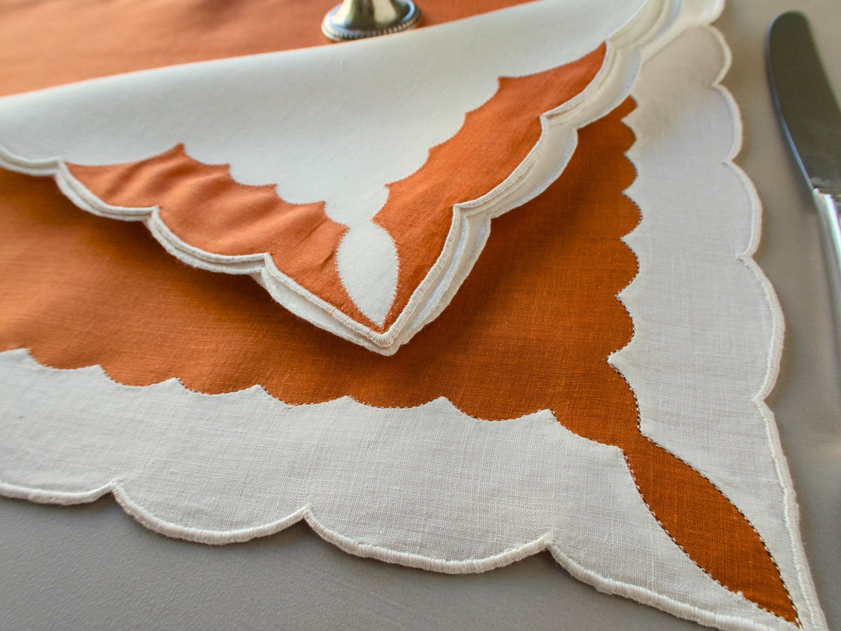 Marghab ‘Minaret’ linen placemat and napkin set in rust and white, hand embroidered in Madeira with bold scalloped appliqué.