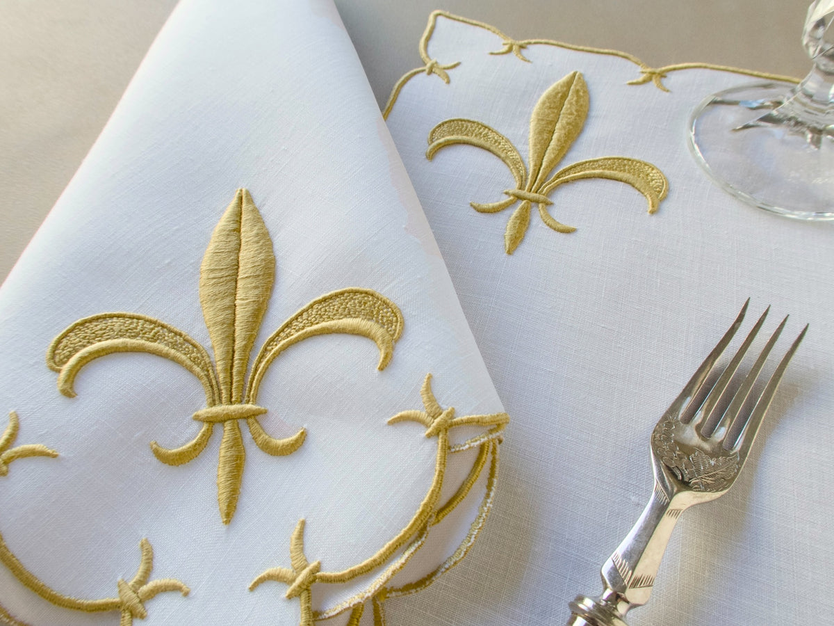 Marghab ‘Fleur de Lys’ linen placemat and napkin set, hand embroidered in Madeira with raised gold satin-stitch fleur-de-lys.