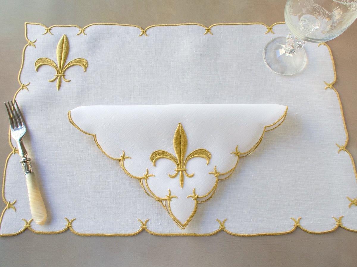 Marghab ‘Fleur de Lys’ linen placemat and napkin set, hand embroidered in Madeira with raised gold satin-stitch fleur-de-lys.