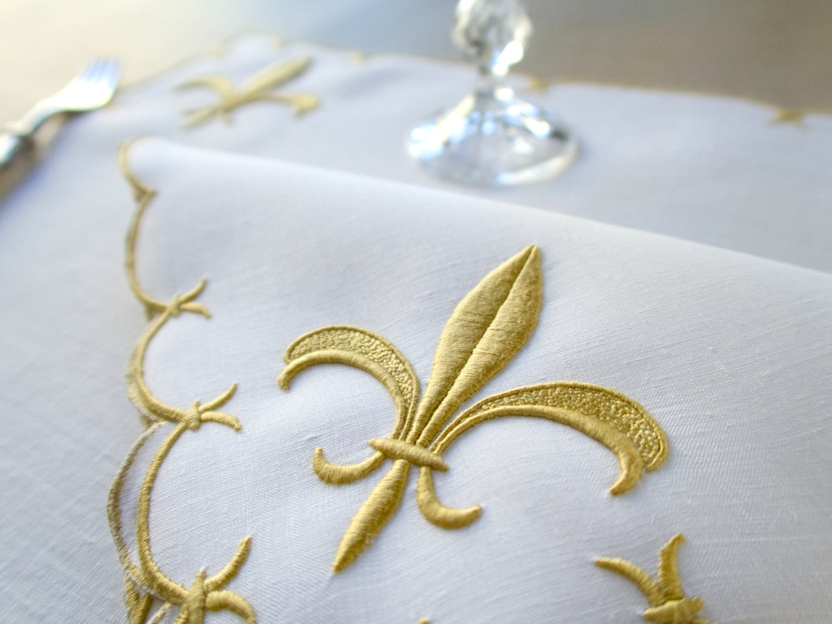 Marghab ‘Fleur de Lys’ linen placemat and napkin set, hand embroidered in Madeira with raised gold satin-stitch fleur-de-lys.