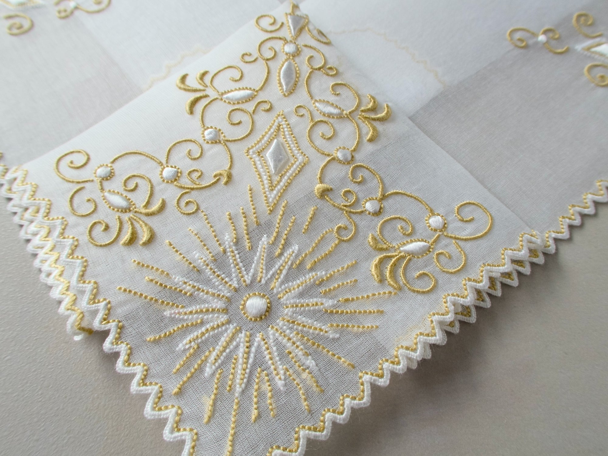 Vintage Marghab handkerchief in the “Jewel” pattern, with gold embroidery on sheer organdy and a linen center. Hand embroidered in Madeira.