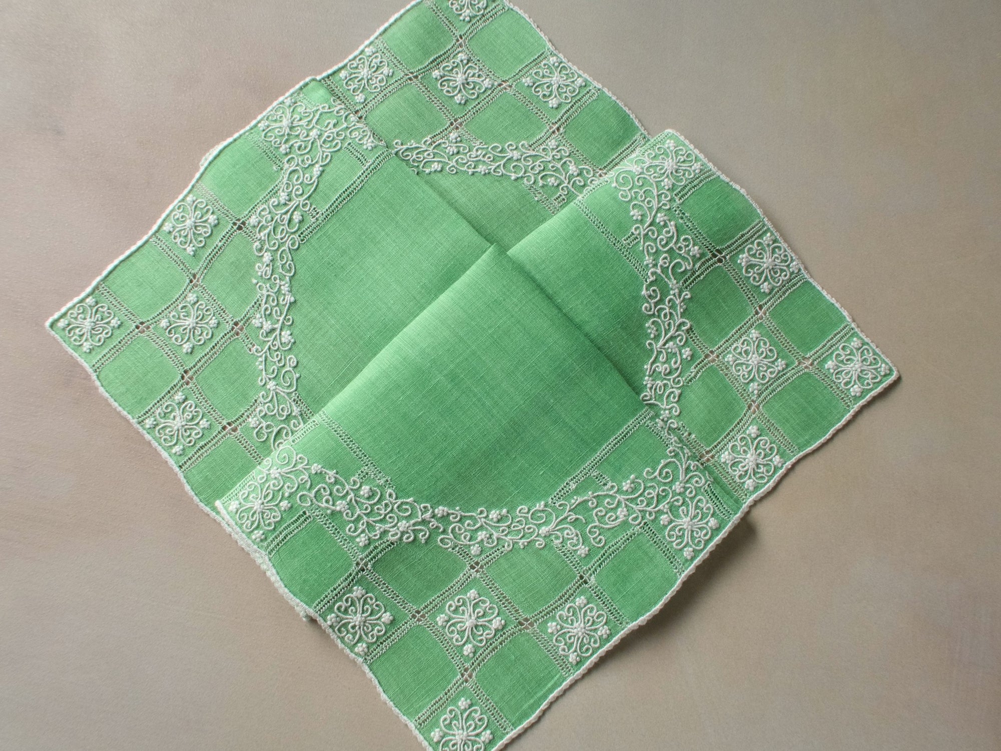 Vintage Marghab “Wreath Over Square” handkerchief, hand embroidered in white on green linen with intricate raised stitching and fine caseado bastido edging.
